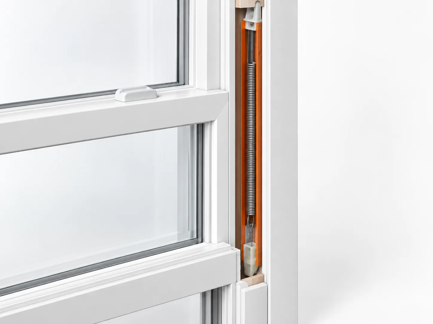 Window jamb cutaway exposing a spring balance, with its narrow channel housing highlighted orange.