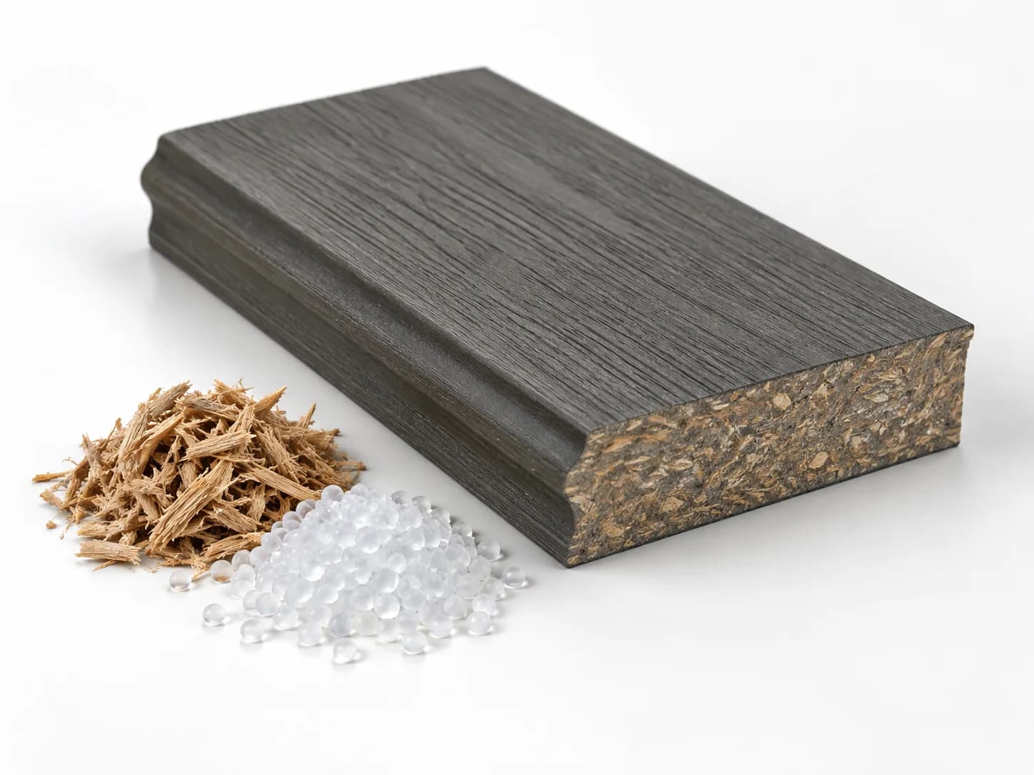 Composite board sample with an exposed blended core beside wood fibres and polymer granules.
